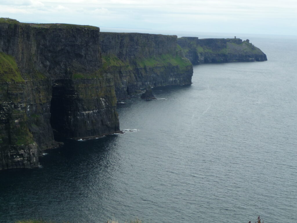 Cliffs of Moher stretching into the distance above a calm sea