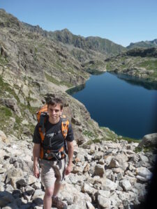 Jon R Kershner hiking in Maritime Alps with a lake in background